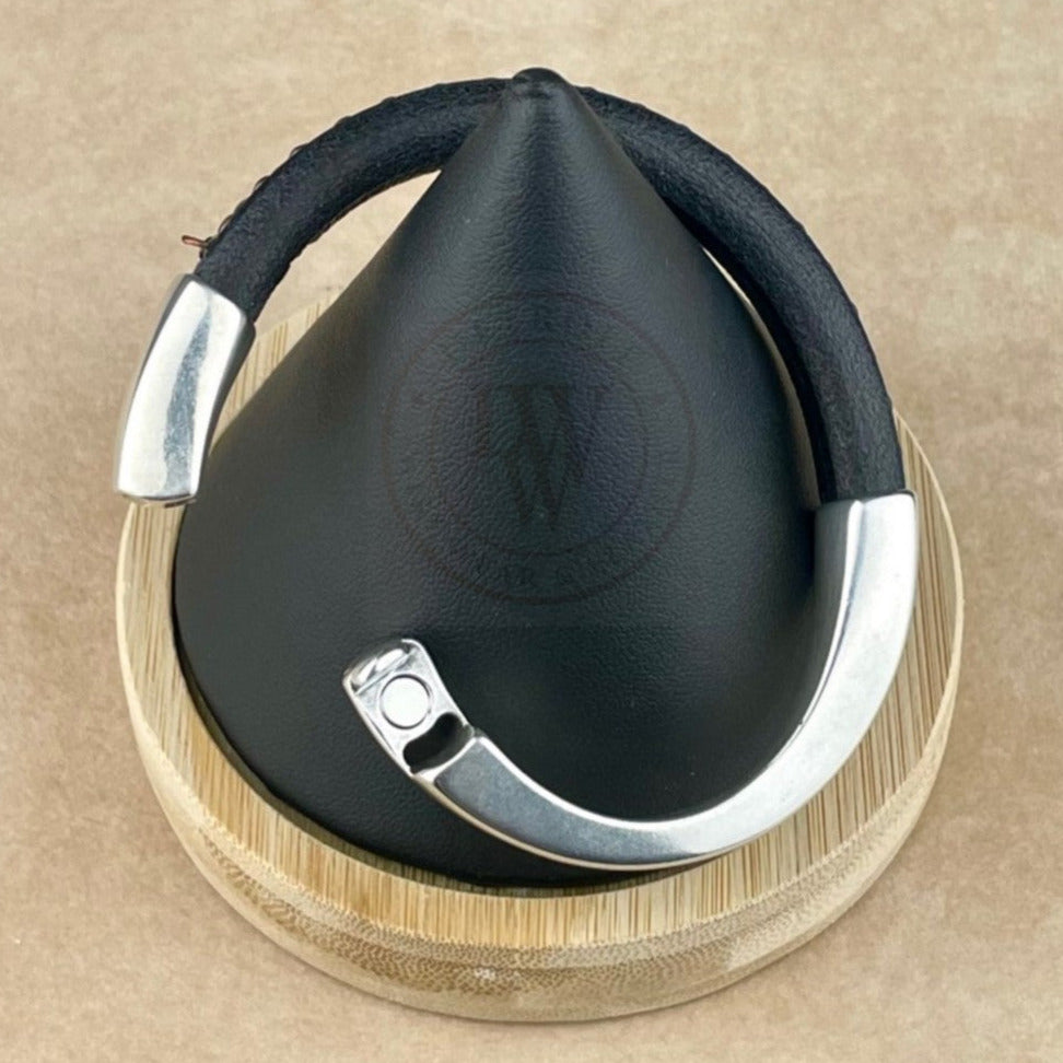 This unisex bracelet features a black leather band accented with an antique copper chain for a warm, rustic touch. The long, arcing, antique silver magnetic clasp ensures a secure and effortless closure. The mix of dark leather, vintage copper, and aged silver creates a distinctive, timeless look that adds subtle character to any style.